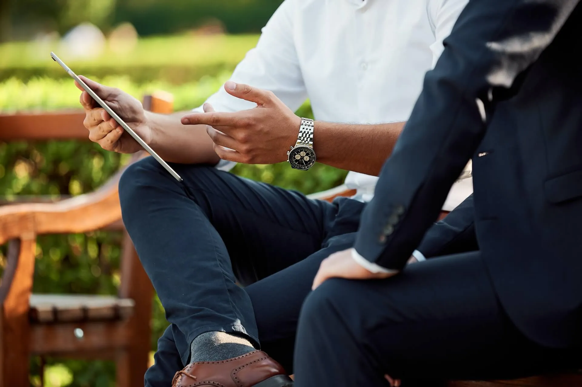 A man showing another person something on a tablet.
