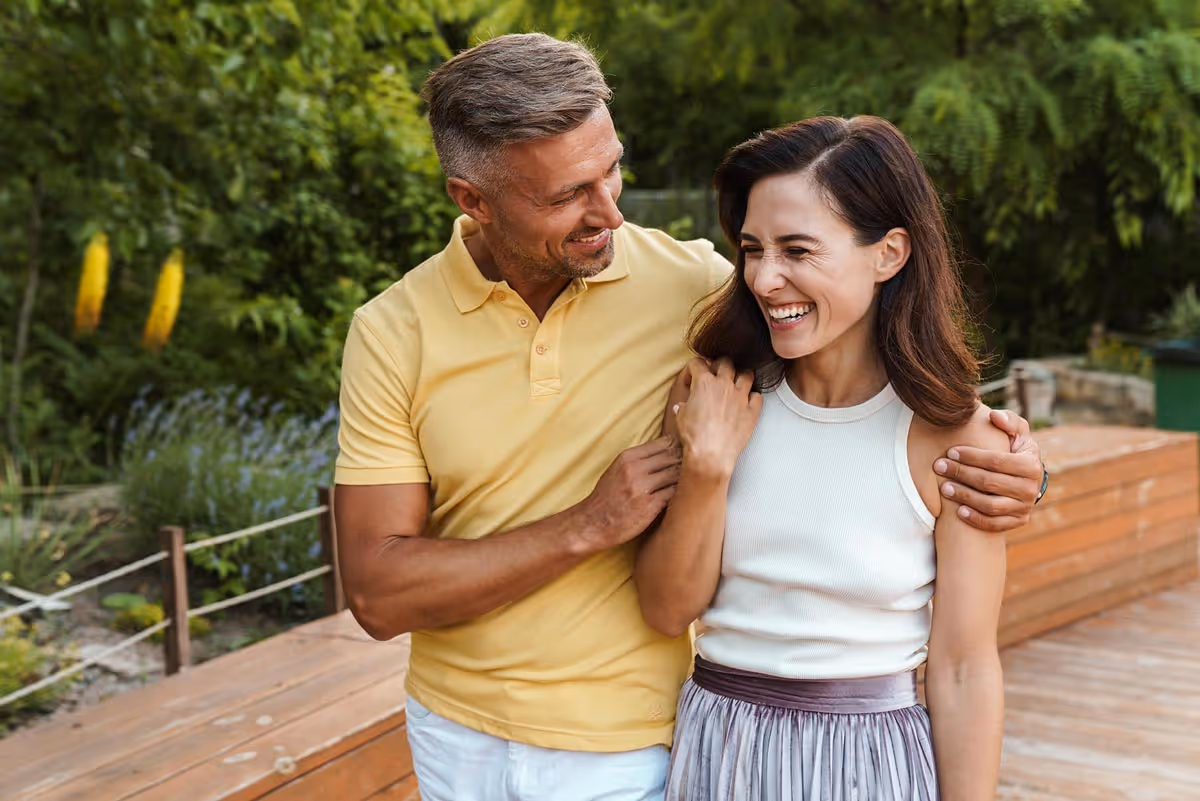 A happy husband and wife walking at a park.