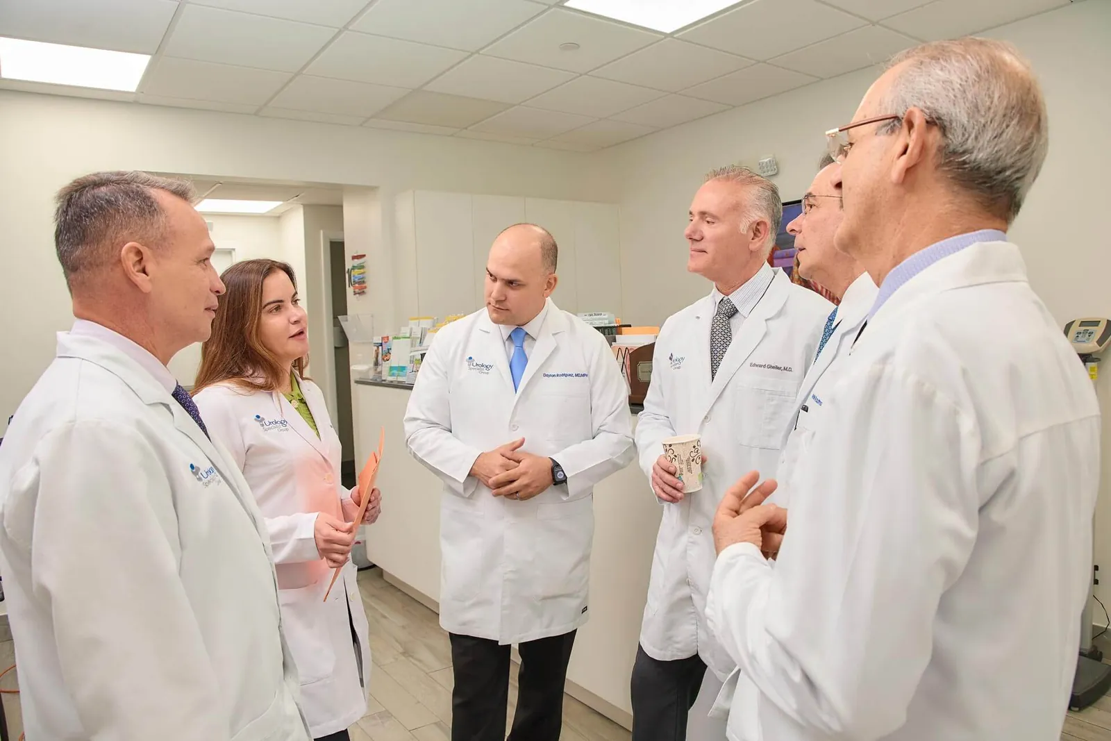 Six providers of the practice conferring in a clinic hallway.