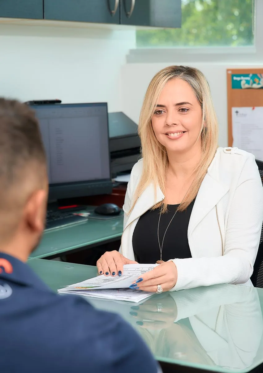 A member of the front-office team reviewing paperwork with a patient at the Hialeah office.