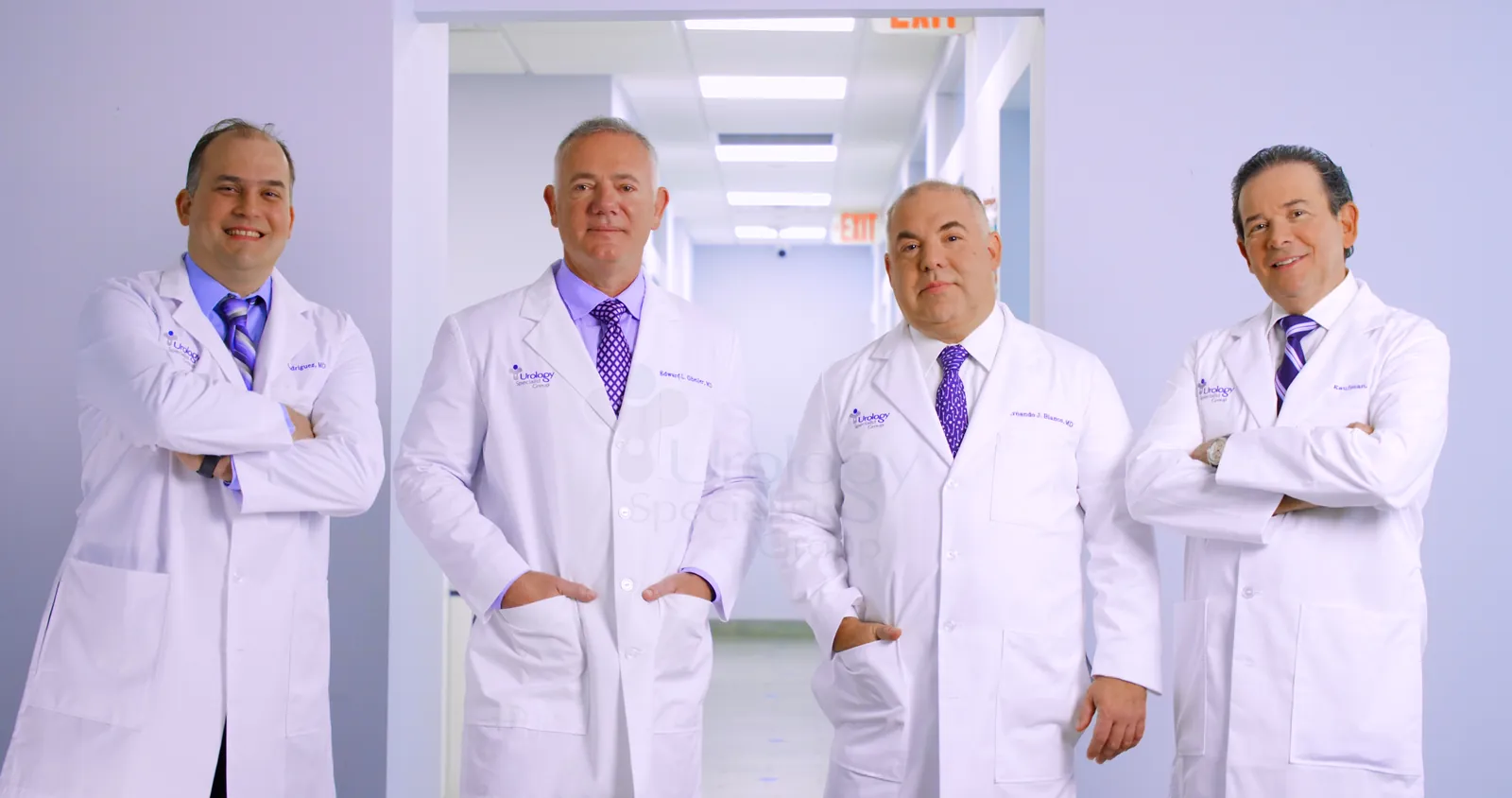 Four board-certified urologists of the practice standing together in the clinic hallway.